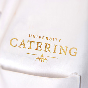 Close-up of a white shirt with the University Catering logo